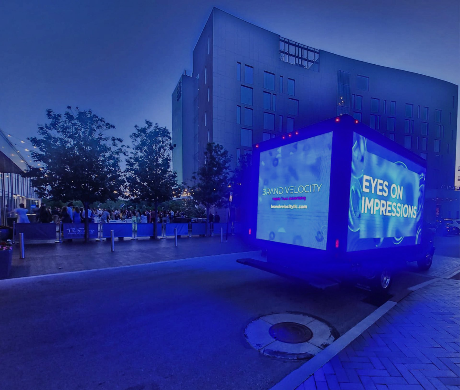 A truck driving down the street with a large screen.