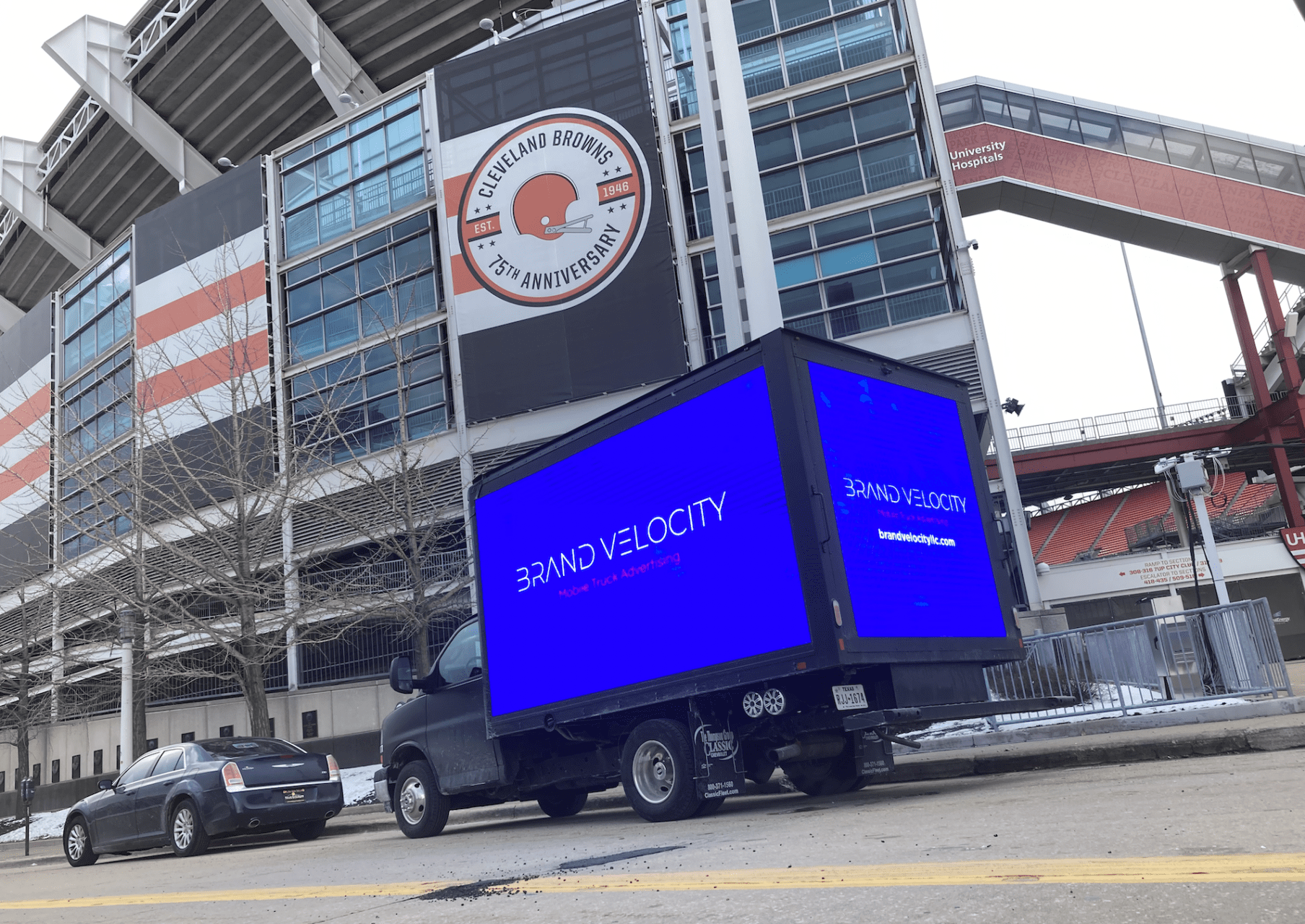 A truck driving down the street in front of an arena.