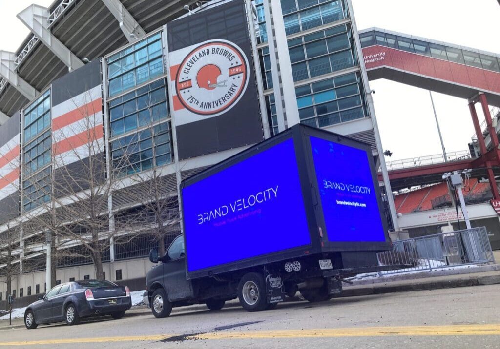 A truck driving down the street in front of an arena.